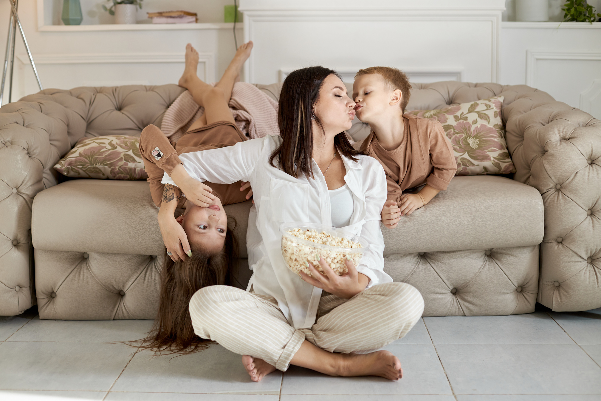 Mom and kids eat popcorn at home 